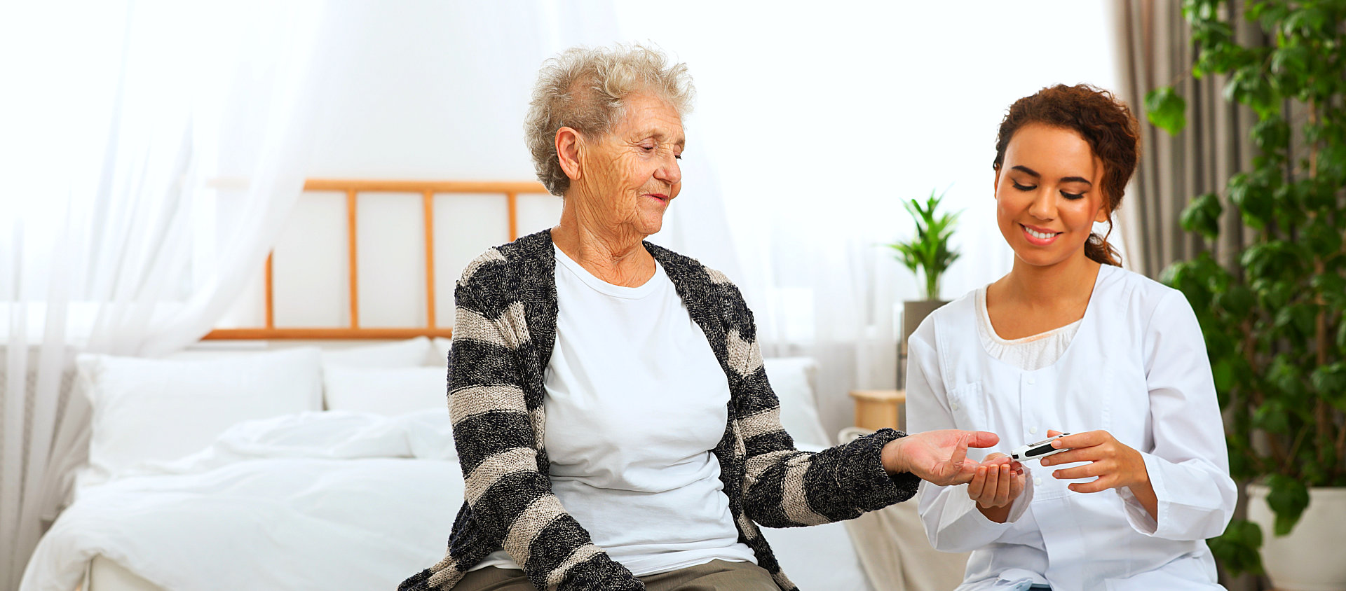 caregiver monitoring the sugar level of senior woman