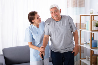 nurse assisting senior man to walk