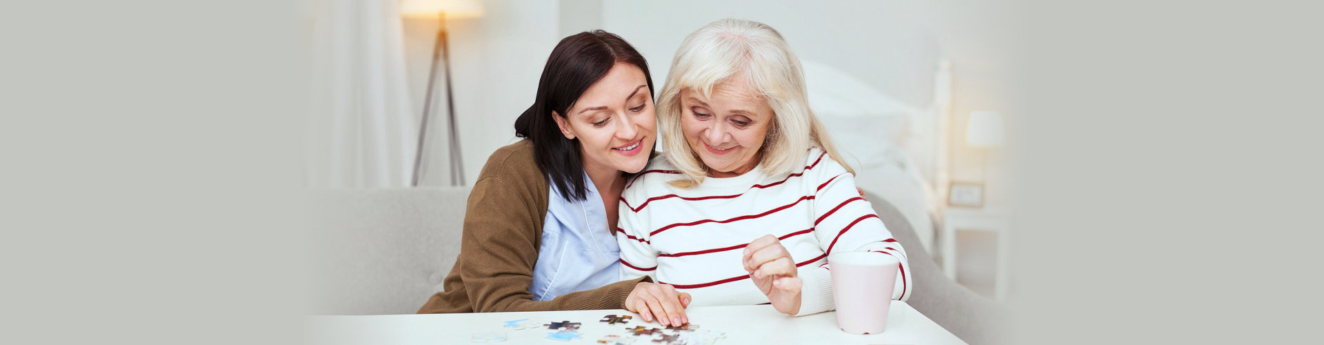 caregiver and senior woman solving a puzzle