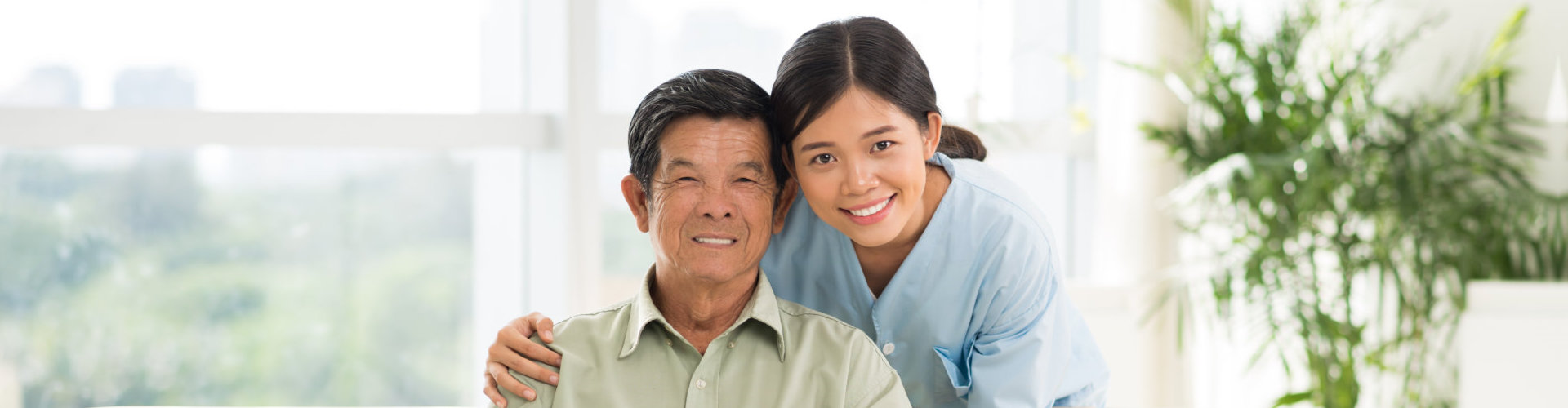 caregiver and senior man are smiling